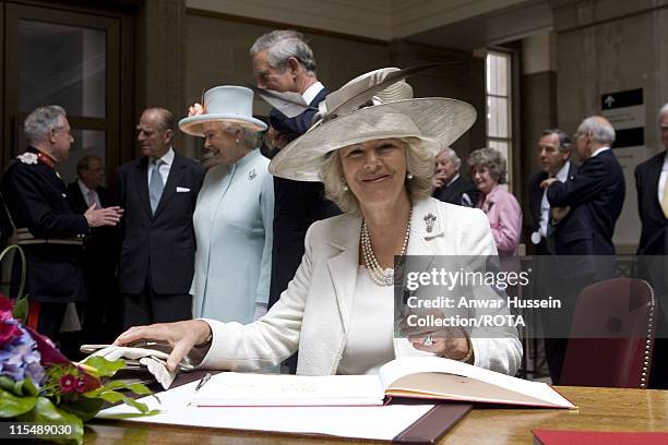 Camilla, Duchess of Cornwall signs the visitors book when she visits the National Museum of Wales in Cardiff with Prince Charles, Prince of Waes,...