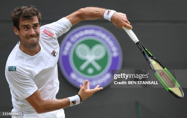 Argentina's Guido Pella serves to Spain's Roberto Bautista Agut during their men's singles quarter-final match on day nine of the 2019 Wimbledon...