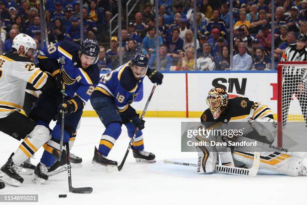 Goaltender Tuukka Rask of the Boston Bruins defends his net as John Moore of the Boston Bruins checks Alexander Steen of the St. Louis Blues during...