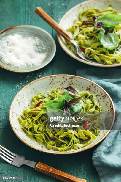 vegetarische spinazie pasta met rucola en basilicum pesto - pestosaus stockfoto's en -beelden
