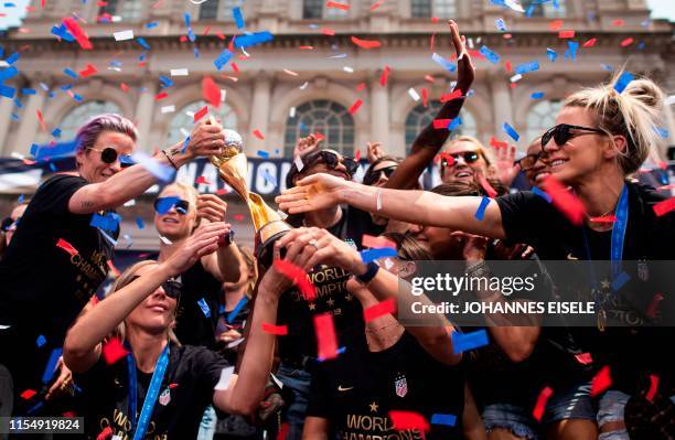 Members of the World Cup-winning US women's team take part in a ticker tape parade with their trophy for the women's World Cup champions on July 10,...