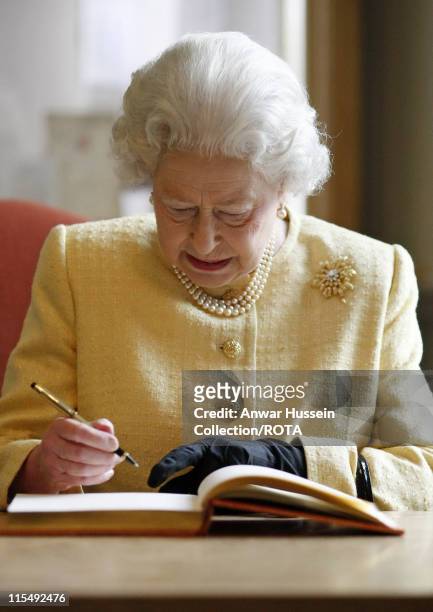 Queen Elizabeth ll signs the visitor's book when she visits the Royal Academy of Music on December 13, 2007 in London, England.