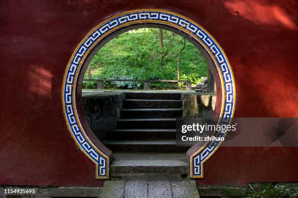chinese red wall courtyard with arched door - chinese architecture stockfoto's en -beelden