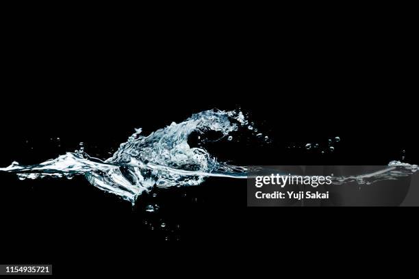 water splashing side view black back - acqua fluente foto e immagini stock