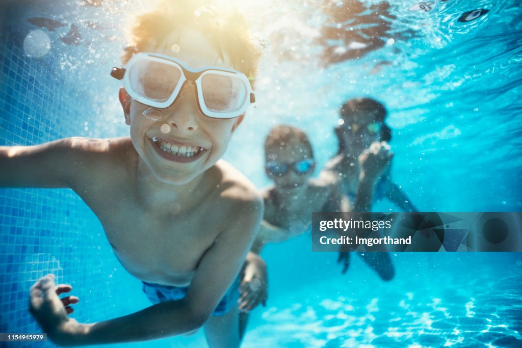 Gosses jouant sous l’eau dans la piscine