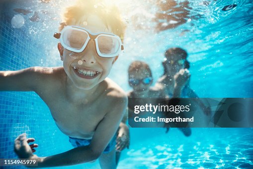 Kids playing underwater in pool Kids playing underwater in pool