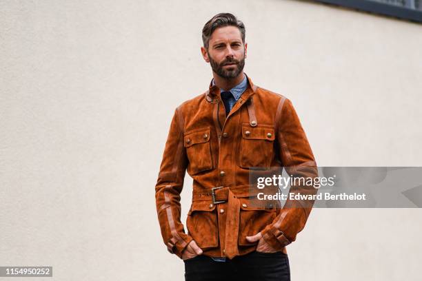 David Blakeley wears a brown/orange suede jacket, black pants, a blue shirt, during London Fashion Week Men's June 2019 on June 09, 2019 in London,...