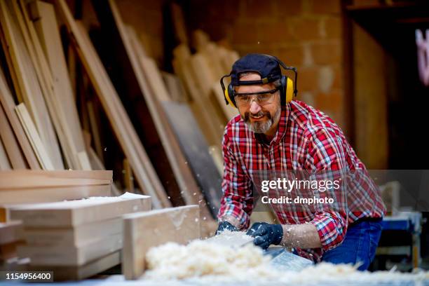 carpenter sawing a board with a table saw - table saw stock pictures, royalty-free photos & images