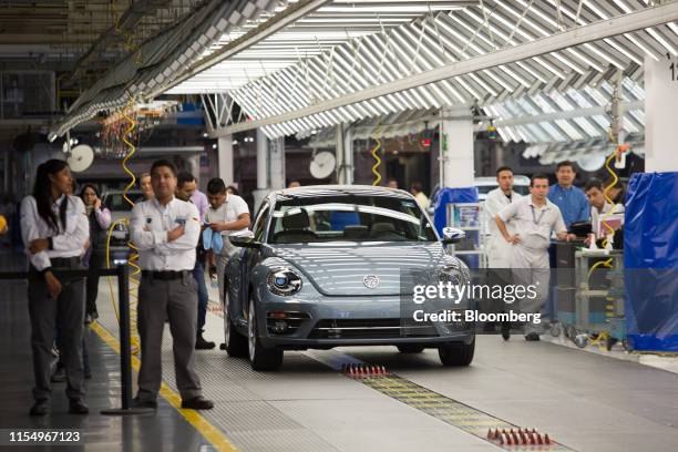 Volkswagen AG Beetle compact vehicle drives off the production line during an end of production celebration at the company's factory in Puebla,...