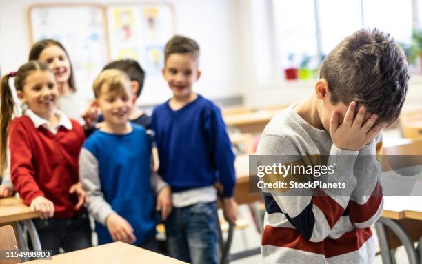 unhappy schoolboy in classroom - sneering stock pictures, royalty-free photos & images