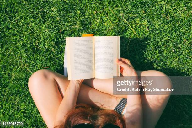 summer reading in the park - book reading stockfoto's en -beelden