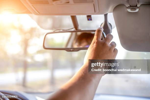 hand adjusting rear view mirror. - rear view mirror - fotografias e filmes do acervo