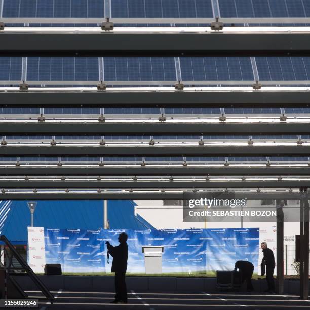 Visitor takes pictures of solar panels on September 19, 2010 during the inauguration of a solar panel installation on the car park of French auto...