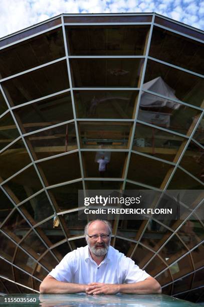 French designer, Eric Wasser poses on August 17, 2011 in front of the "Heliodrome", a bioclimatic solar house that he created in Cosswiller, eastern...