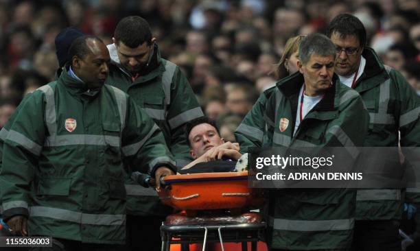 Manchester United's English defender Phil Jones is carried off the field by medics during the English Premier League football match between Arsenal...