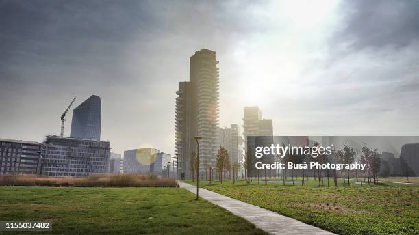 new architectures and highrise developments (including the apartment towers of torre solaria) as seen from the public park biblioteca degli alberi in the porta nuova district of milan, italy - milan skyline stock pictures, royalty-free photos & images