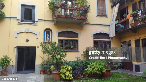 housing courtyard with small garden in milan, italy - cortile foto e immagini stock