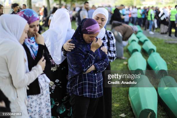 Relatives of Srebrenica Genocide victims mourn by the coffins at the SrebrenicaPotocari Memorial, ahead of the burial of recently identified remains...