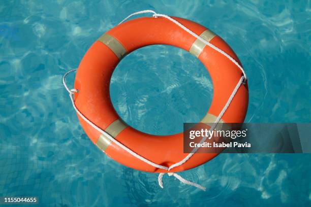 buoyancy life ring floating in calm water - rettungsring stock-fotos und bilder