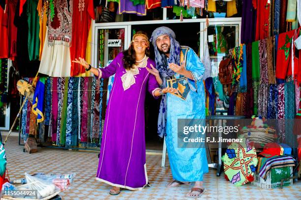 couple of tourists dressed in traditional moroccan clothes - maroc business stock-fotos und bilder