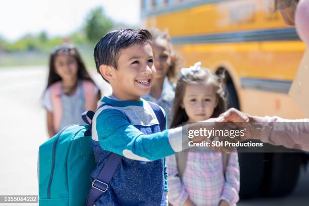 schoolboy greets new school bus driver excitedly - new adventure stock pictures, royalty-free photos & images