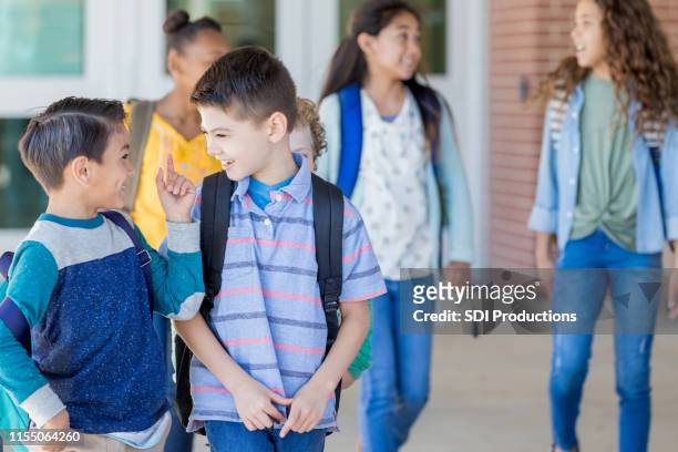 schoolboy tells funny story to best friend - last day of school stock pictures, royalty-free photos & images