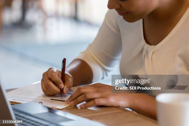 la mujer hispana llena la solicitud de empleo en la cafetería - form filling fotografías e imágenes de stock