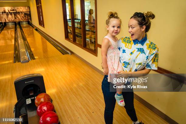 Olivia Wilde teaches Daisy Sudeikis how to bowl while participating in bowling at Pinstripes during the Big Slick Celebrity Weekend benefiting...
