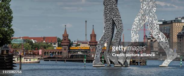 Train crosses the Oberbaumbrücke bridge. In front of it stands the sculpture Molecule Man by the American sculptor Jonathan Borofsky. Photo: Paul...