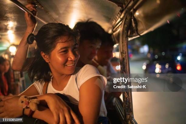 multi-ethnic asian friends riding jeepney in manila at night - filipino stock pictures, royalty-free photos & images