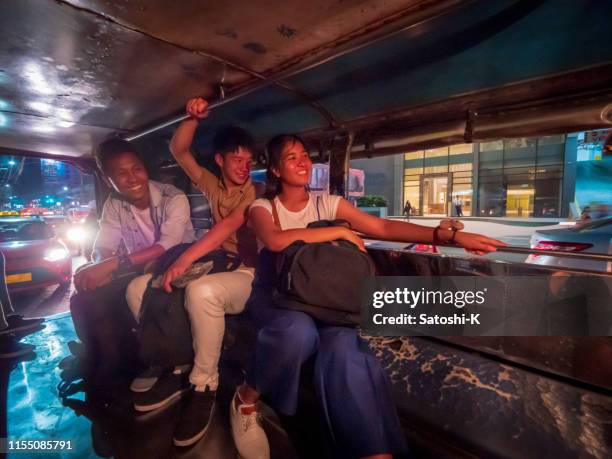 multi-ethnic asian friends riding jeepney in manila at night - philippines jeepney stock pictures, royalty-free photos & images