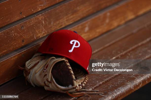 Detailed view of a glove and Philadelphia Phillies hat is seen in the dugout prior to the MLB game between the Philadelphia Phillies and the Los...