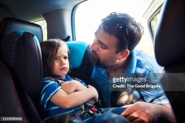 father putting son into car seat - tantrum stock pictures, royalty-free photos & images
