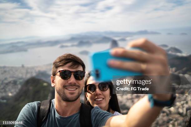 tourist couple taking a selfie in rio de janeiro - tourism in brazil stock pictures, royalty-free photos & images