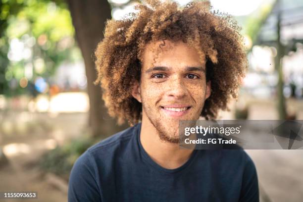 verticale de jeune homme de sourire sur la rue - cheveux roux bouclés photos et images de collection