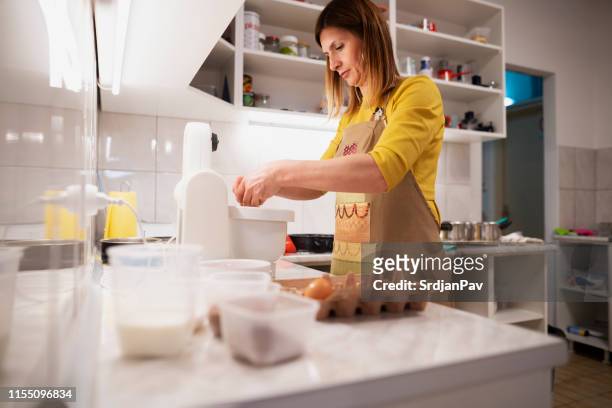 female chef mixing ingredients at a kitchen counter - carton of eggs stock pictures, royalty-free photos & images