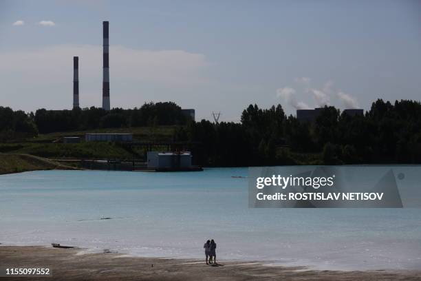 Couple walks by a Novosibirsk energy plant's ash dump site - nicknamed the local "Maldives" - on July 11, 2019. - An industrial dump site in Siberia...