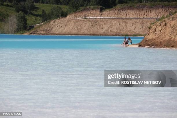 Couple rests by a Novosibirsk energy plant's ash dump site - nicknamed the local "Maldives" - on July 11, 2019. - An industrial dump site in Siberia...