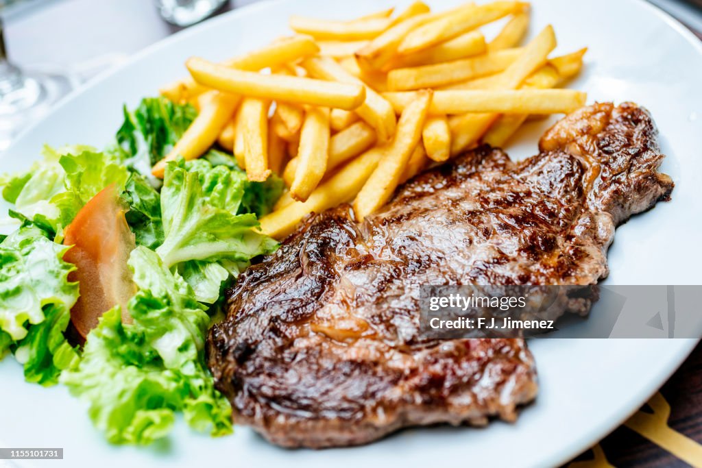 Plate of beef fillet with salad and chips