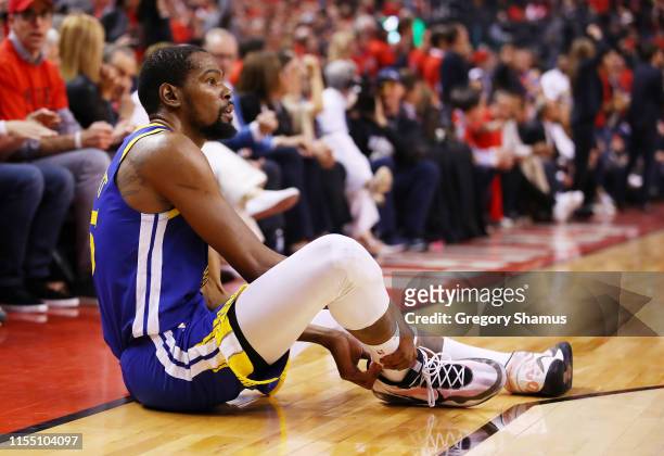 Kevin Durant of the Golden State Warriors reacts after sustaining an injury during the second quarter against the Toronto Raptors during Game Five of...