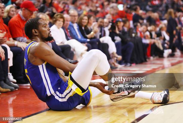 Kevin Durant of the Golden State Warriors reacts after sustaining an injury during the second quarter against the Toronto Raptors during Game Five of...