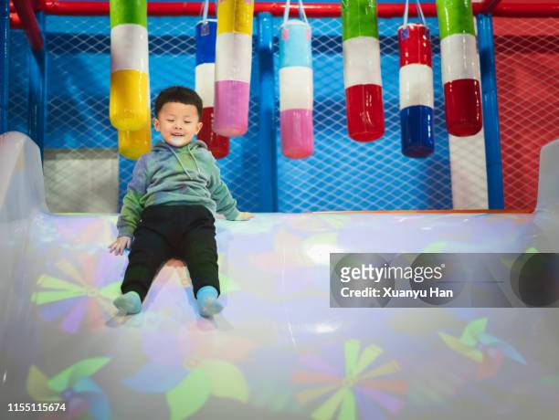 little boy playing on the slide in the playground - who could play young han solo stock pictures, royalty-free photos & images