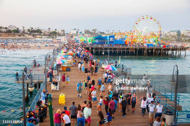überfüllte santa monica pier mit touristen und einheimischen - santa monica pier stock-fotos und bilder