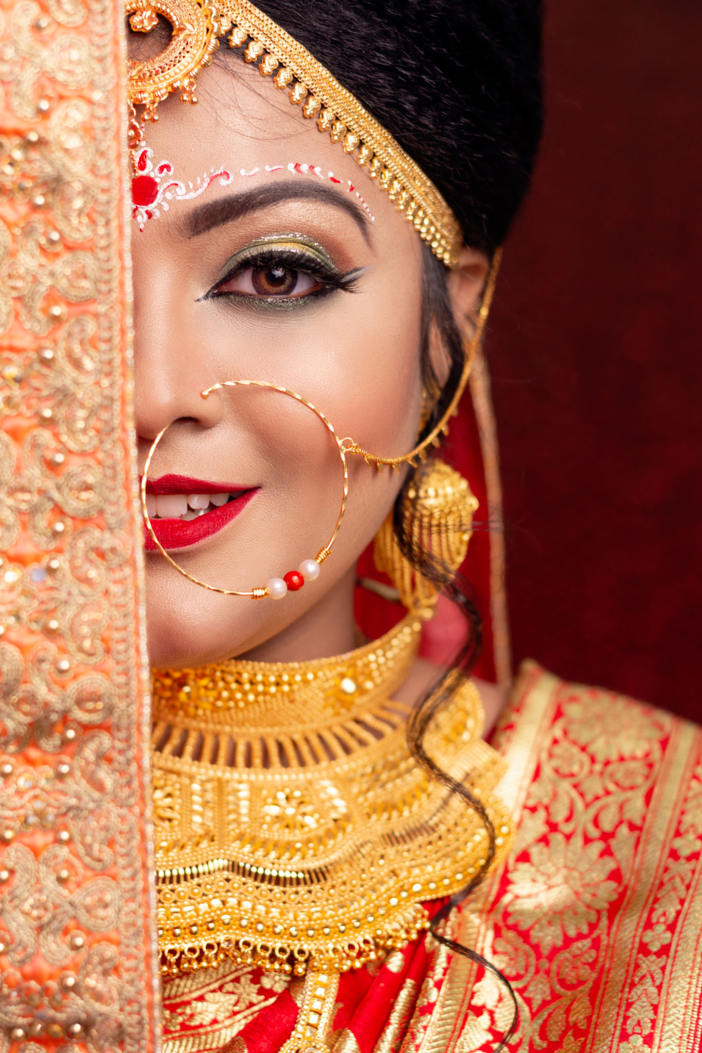 A pretty young female model wearing traditional indian / Bangladeshi bridal outfit with heavy gold jewelry and makeup A pretty young female model wearing traditional indian / Bangladeshi bridal outfit with heavy gold jewelry and makeup