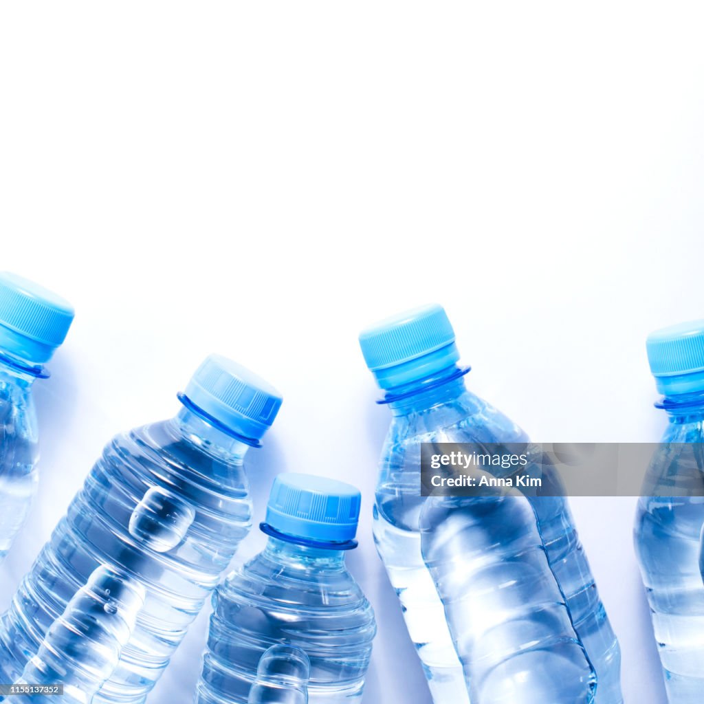 Varias botellas de agua potable sobre fondo blanco