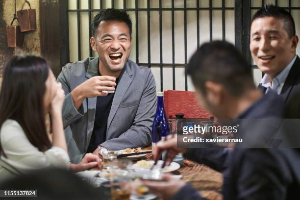 東京レストランでドリンクや食べ物を楽しむ日本人の友達 - 酒場　日本 ストックフォトと画像