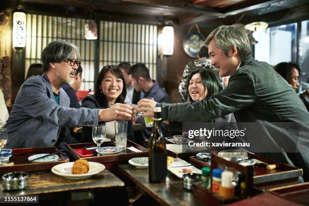 japanese couples toasting at tokyo sushi bar and restaurant - sake stock pictures, royalty-free photos & images