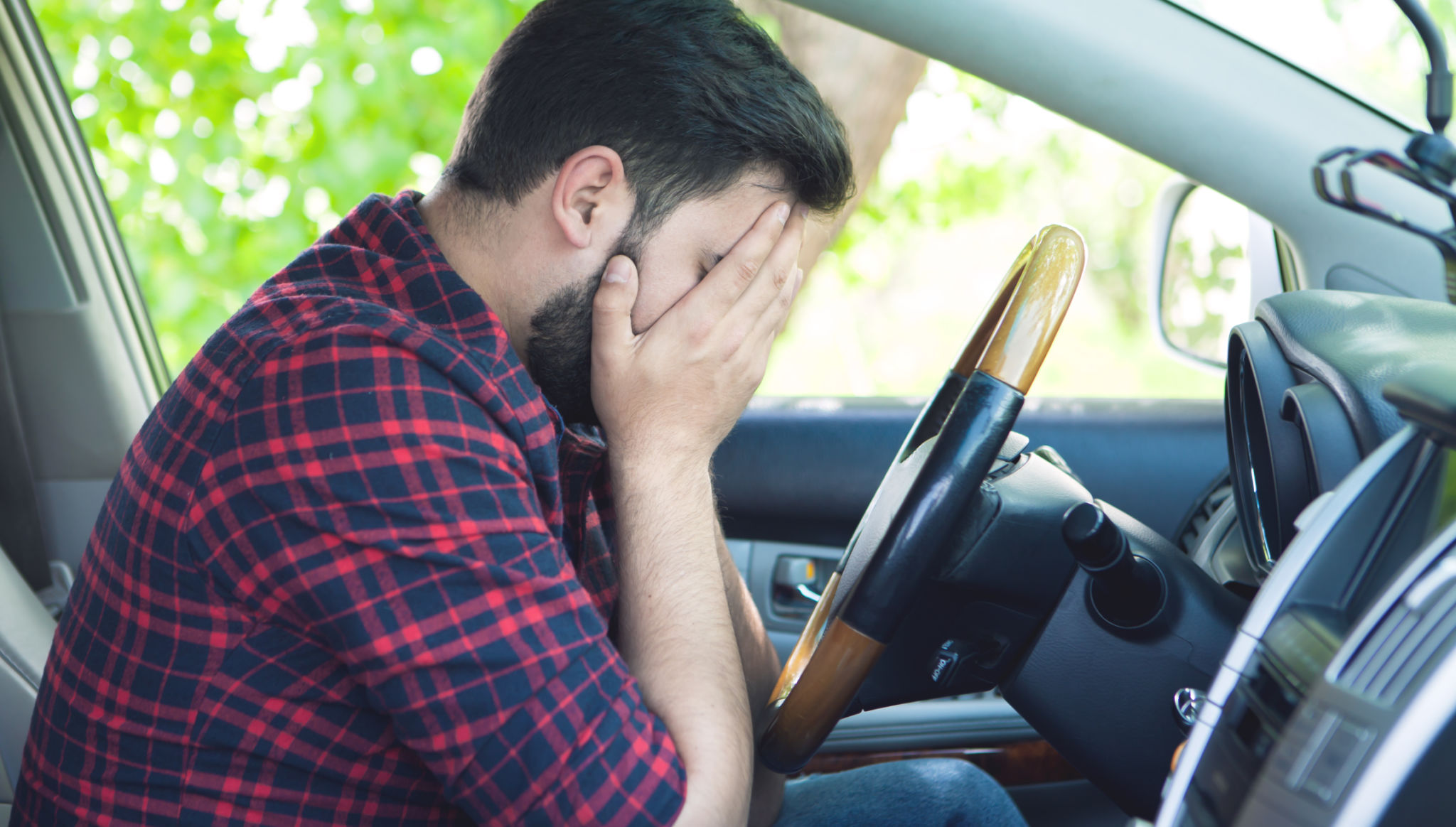 tired, angry, young driver covers his face by hands tired, angry, young driver covers his face by hands