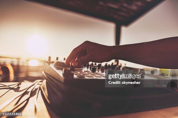 fermez-vous vers le haut d’un dj jouant de la musique sur la plage au coucher du soleil. - beach music festival photos et images de collection