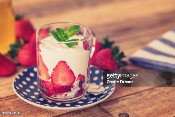 yogurt with fresh strawberries in glass, close-up - strawberries and cream stock pictures, royalty-free photos & images
